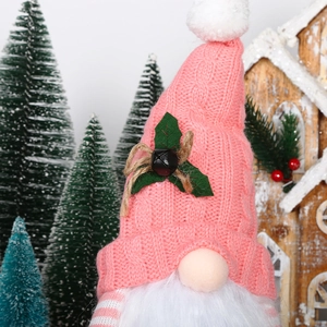 Close-up of pink knit hat Christmas gnome with bells and soft white beard decor