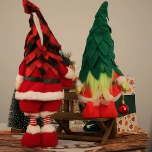 Detail der weihnachtlichen Plüsch-Gnome mit Karomuster und Lichteffekt auf einer Holzbank
