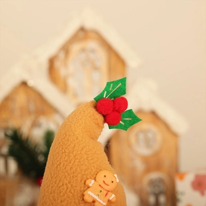 Détail de bonhomme en pain d'épices et houx sur un bonnet de Noël en maille rousse
