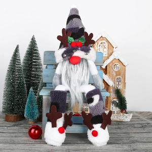 Christmas gnome doll with striped hat and antlers sitting on a blue bench