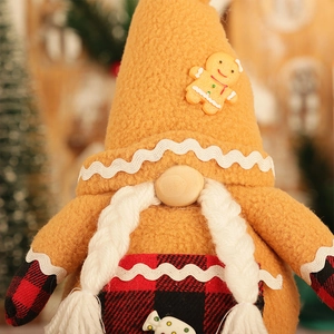 Détail du gnome de Noël en peluche avec chapeau pain d'épices et tablier à carreaux rouge