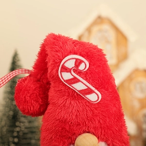 Détail du chapeau de gnome en peluche rouge avec canne en sucre brodée et ruban