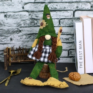 Green coffee gnome plush with pointed hat and long braids on a rustic wooden base