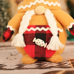 Détail d'un gnome de Noël en peluche avec décor pain d'épices et barbe tricotée orange