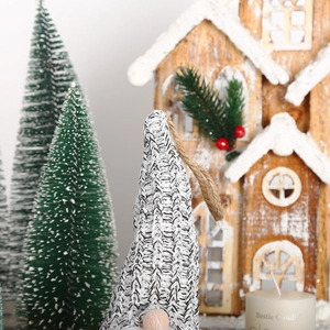 Close-up of Nordic knitted Christmas gnome ornament with wooden nose and rustic twine loop