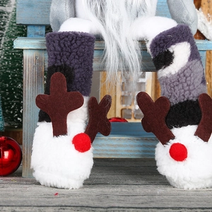 Close-up of plush gnome legs with white faux fur reindeer boots and brown antlers