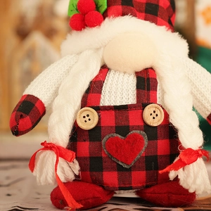 Detail of a Christmas gnome with buffalo plaid hat, braided beard and red heart ornament