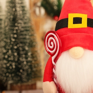 Christmas gnome plush doll with red hat and lollipop in festive holiday setting