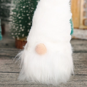 Close-up of a white plush Christmas gnome decoration with a soft knitted hat