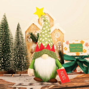 Detail of Christmas gnome plush with Noel tag, polka dot hat and green fabric texture