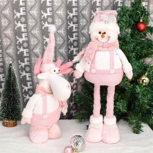 Pink sequin plush Christmas reindeer and snowman figurines on white snow surface