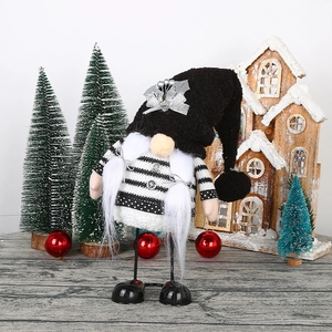 Black and white knit wedding gnome doll with silver holly leaves on a festive background
