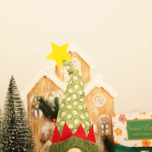 Detailed view of a green polka dot Christmas gnome hat featuring a yellow star topper