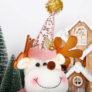 Close-up of pink reindeer plush toy with sequins and golden antlers for Christmas decor