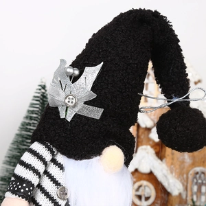 Detailed close-up of a handmade wedding gnome doll with black plush hat and silver bow decoration