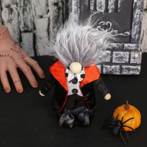 Close-up of Halloween vampire gnome with grey hair and red cape in a spooky scene