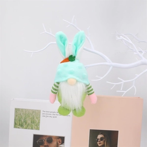 Easter gnome plush with rabbit ears and carrot ornament hanging on a white branch