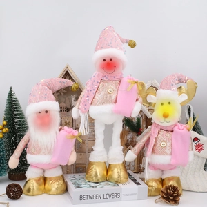 Detailed view of pink and gold Christmas dolls with plush texture and sequins