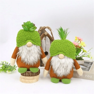 Detail of green Christmas gnomes with succulent hats and plush white beards in forest setting