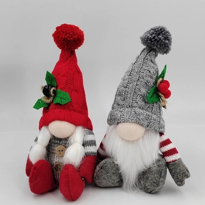 Detailed view of handmade Christmas gnomes with knitted hats and holiday holly berry accents