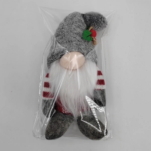 Detailed view of a Christmas gnome doll with grey knitted hat in plastic packaging