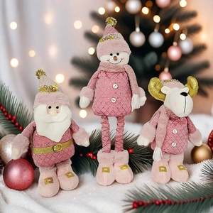 Détails de figurines de Noël roses en peluche avec accents dorés et lumières bokeh douces