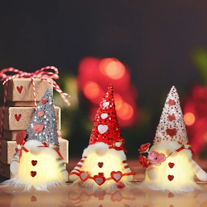 Close-up of three glowing Valentine's Day gnomes with sequins and LED heart lights