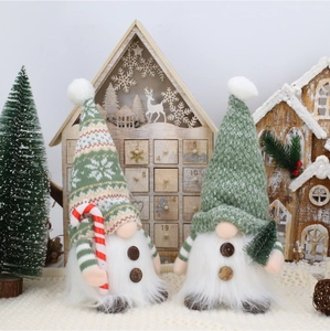 Close-up of festive Christmas gnomes with knitted hats, candy cane and mini tree decor