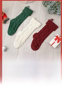 Detail of cable knit Christmas stockings in forest green, ivory white, and burgundy red