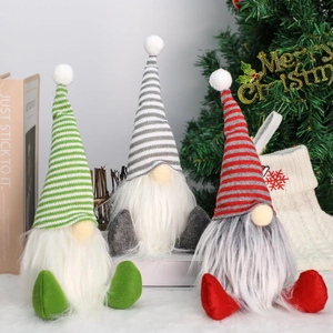 Three Christmas gnome plush dolls with striped hats and white beards on soft white rug