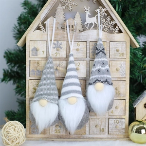 Close-up of three grey and white knitted Christmas gnome ornaments with hanging loops