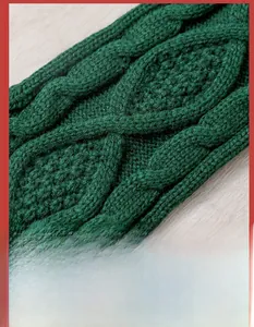 Close-up of deep green cable knit texture for Christmas stockings on wood background