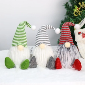Three plush Christmas gnomes with knitted hats and long white beards in festive setting