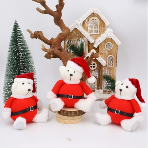 Three white Christmas teddy bears wearing red Santa outfits and hats on a festive display