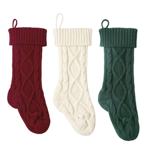 Three-piece knitted Christmas stockings set in red, cream, and green for home holiday decor