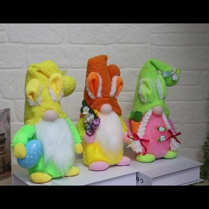 Detail of Easter gnome plush ornaments with bunny ears, holding eggs and flowers