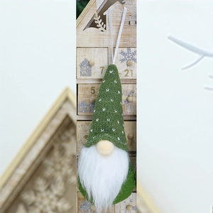 Detail of green knitted gnome Christmas tree ornament with white faux fur beard