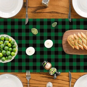 Green buffalo plaid table runner with St. Patrick's Day theme on dark wooden dining table