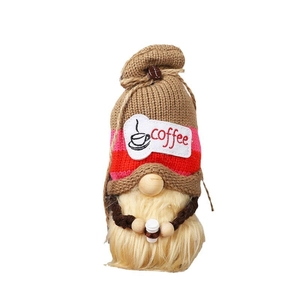 Gnome à café tricoté avec chapeau rayé et mini tasse blanche sur fond blanc immaculé