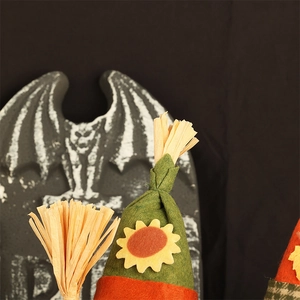 Close-up of Halloween gnome with sunflower green hat and straw details on grave background