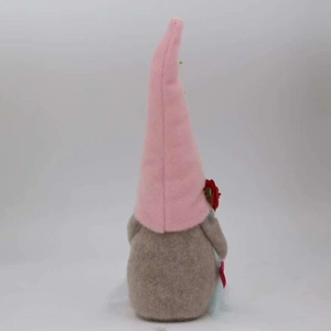 Vue détaillée du nain de jardin en peluche rose avec fleur rouge et corps en feutre gris