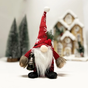 Christmas gnome plush with red knit snowflake hat and lantern on festive background