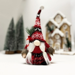 Close-up of Christmas gnome plush with red snowflake hat and candy cane decoration