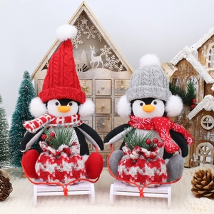 Weihnachts-Pinguin-Plüschfiguren mit Strickmützen auf Holzschlitten für festliche Deko