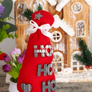 Close-up of red felt Christmas decoration with HO HO HO text and white satin bow detail