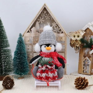 Weihnachts-Pinguin auf Holzschlitten mit festlicher Geschenktüte und Winter-Schal