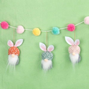 Handmade Easter bunny gnomes with knitted hats and colorful pompoms for festive decoration