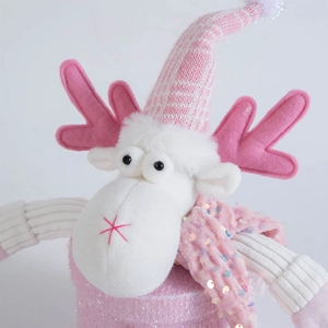 Detail of pink Christmas reindeer plush with sequin body and striped knit hat decoration