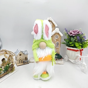 Detailed close-up of a plush Easter gnome with green rabbit ears holding an orange carrot