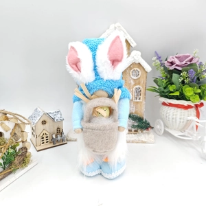 Detail of Easter gnome with long bunny ears and a decorative egg in a small pouch